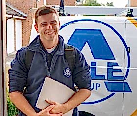 an able group engineer standing in front of a able group service van 